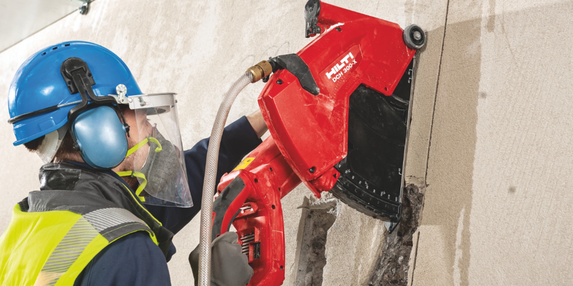 Construction worker cutting into concrete using a DCH 300-X which is fitted with a disc guard to protect workers from broken discs