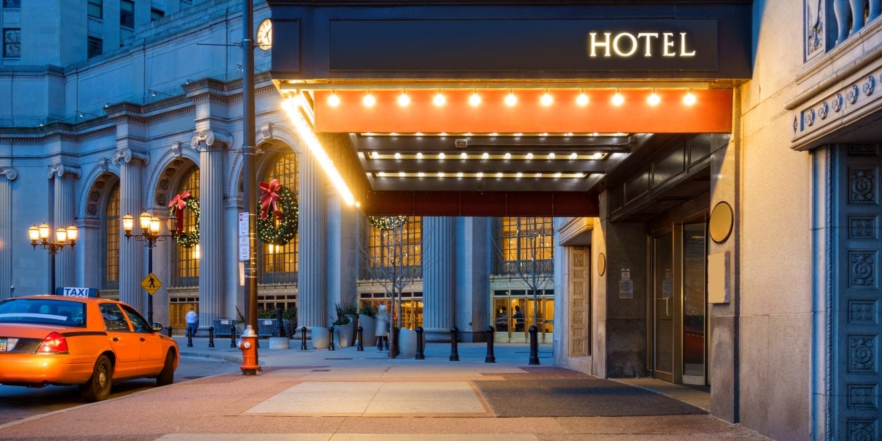472899538 Photo of a hotel entrance and a waiting taxi cab in downtown Cleveland during the winter holidays.